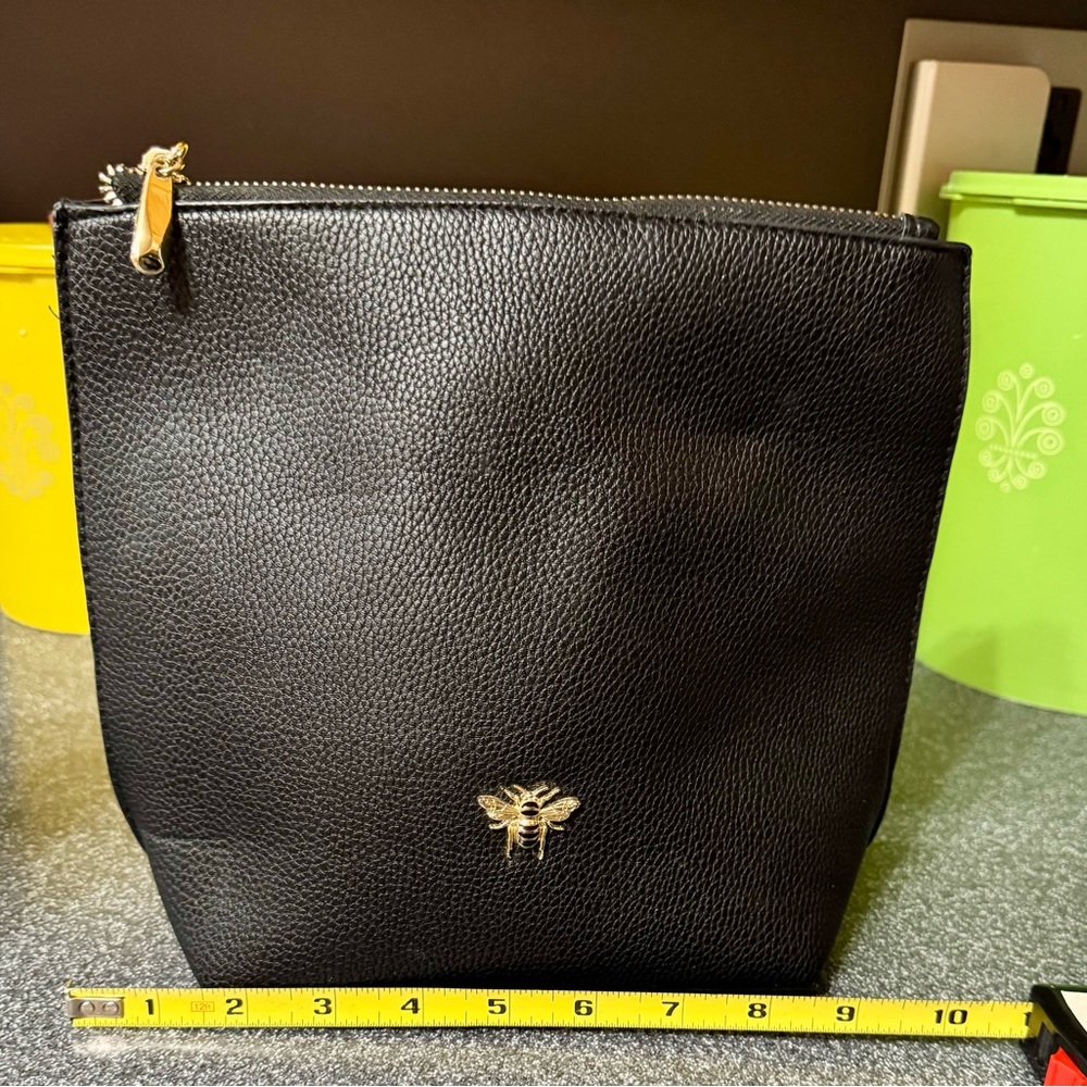 Cosmetic bag with 🐝emblem. It has 2 interior pockets.